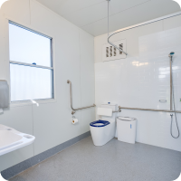 Interior of Access POD Elevate showing accessible toilet, grab rails, shower and vanity bench